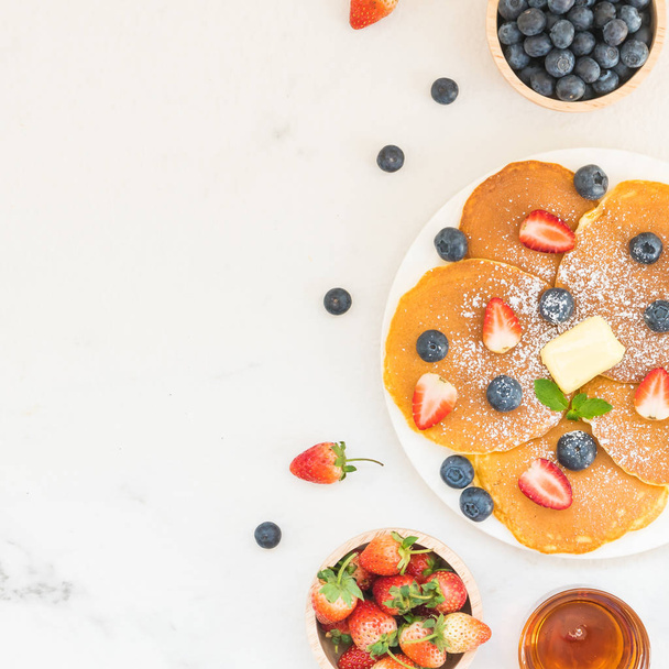 gesundes Frühstücksset mit Pfannkuchen Blaubeeren und Erdbeeren auf Steintischhintergrund - Foto, Bild