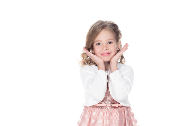 glimlachend kind gebaren in roze jurk, geïsoleerd op wit  - Foto, afbeelding
