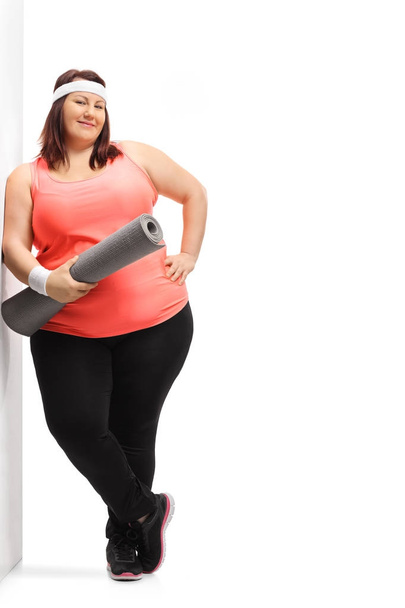 Overweight woman with an exercise mat - Foto, Imagen