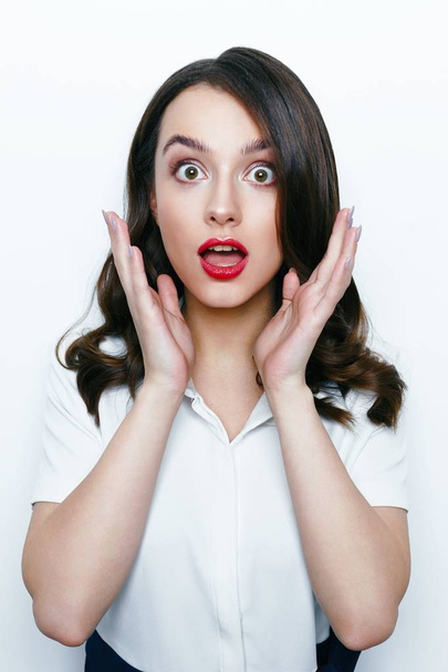 Portrait of excited young brunette woman on white background  - Foto, afbeelding