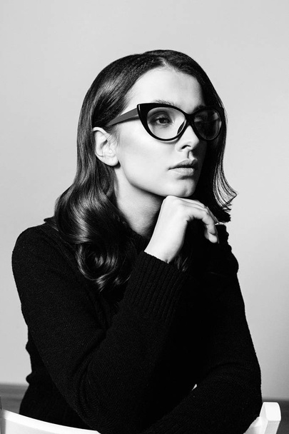 Portrait of pretty young brunette woman in stylish eyeglasses posing in studio - Valokuva, kuva