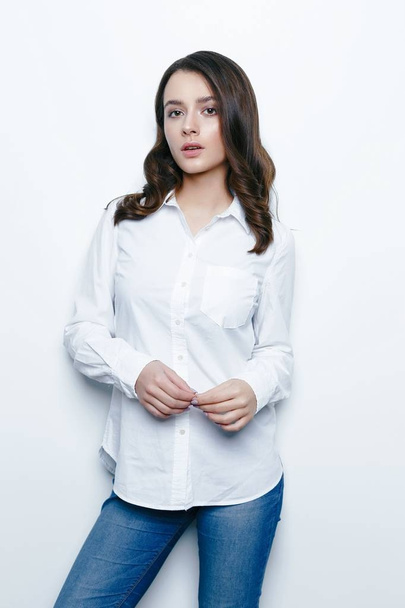 Pretty young brunette woman posing against white studio background  - Fotó, kép