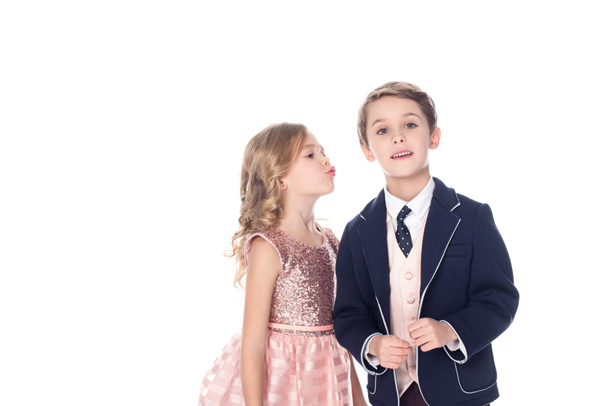 beautiful little girl able to kiss boy in suit looking at camera isolated on white - Fotoğraf, Görsel