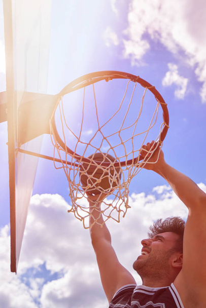 Баскетболист в действии летит высоко и забивает голы
 - Фото, изображение