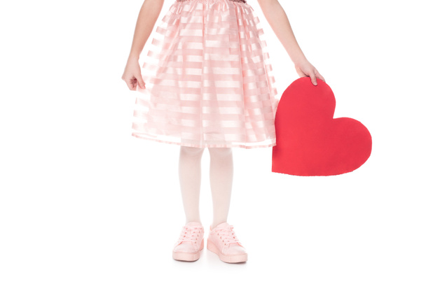 cropped shot of little child in pink dress holding red heart symbol isolated on white - Фото, изображение