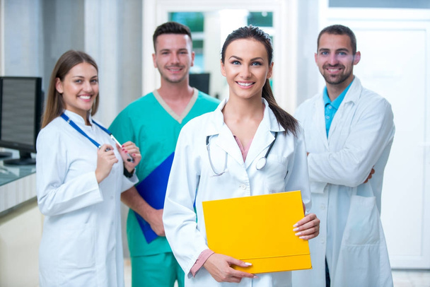 clinic, profession, people, health care and medicine concept - happy group of medics or doctors at hospital corridor - Фото, изображение