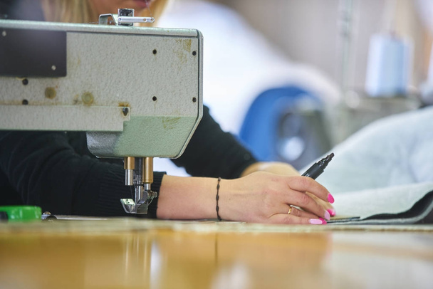 Seamstress or worker in a factory sewing with a industrial sewing machine - Foto, Imagem