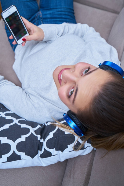 Young woman with headphones listening to music at home - Foto, Imagen