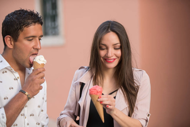 Cheerful couple eating ice cream cones - Foto, Imagen
