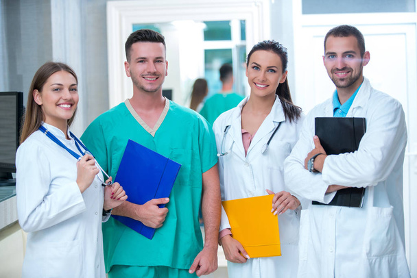 clinic, profession, people, health care and medicine concept - happy group of medics or doctors at hospital corridor - Фото, изображение