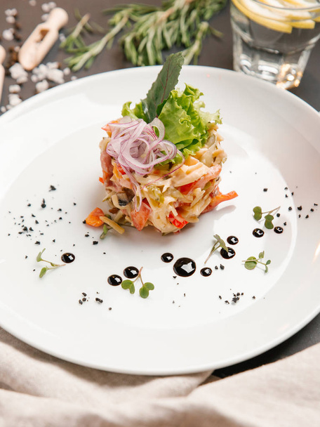 овочевий салат з майонезним соусом і подрібненою цибулею зверху, подається на білій тарілці
 - Фото, зображення