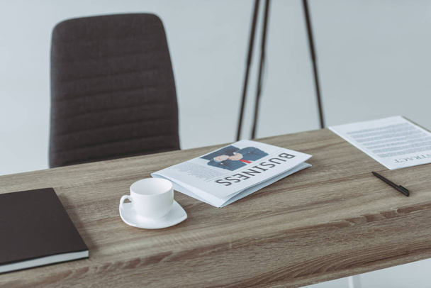 cup and business newspaper on table on gray - Foto, imagen