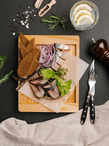 Scombre tranché servi avec oignon et pain de seigle sur plateau en bois
 - Photo, image