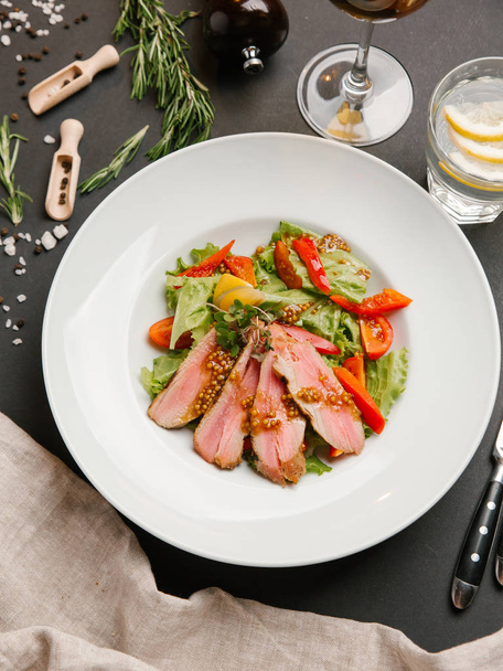Steak avec salade verte de légumes et moutarde française sur assiette blanche
 - Photo, image