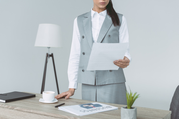 cropped image of businesswoman holding document isolated on gray - Foto, Imagem