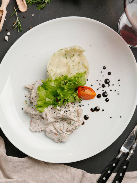 тушкована курка та картопля з кропом, подається з салатом на білій тарілці
 - Фото, зображення