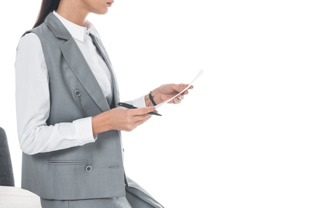 cropped image of businesswoman leaning on table and holding documents isolated on white - Foto, afbeelding
