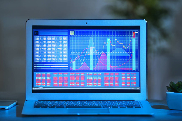 Monitor of laptop with stock data on table - Φωτογραφία, εικόνα