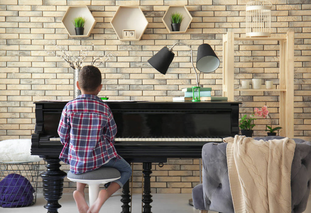 Little African-American boy playing piano indoors - Foto, afbeelding