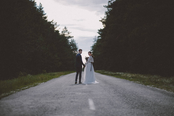 Married couple looking back on forest road - Foto, Imagen