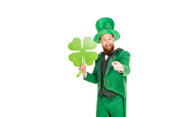 leprechaun in green suit pointing and holding clover, isolated on white - Photo, Image
