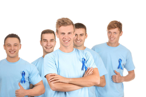 Young men in t-shirts with blue ribbons on white background. Prostate cancer awareness concept - Фото, изображение