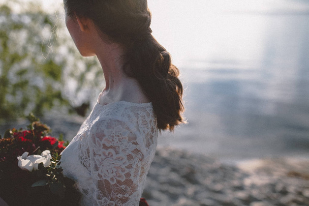 Cropped view of woman in wedding dress on shore - Photo, Image