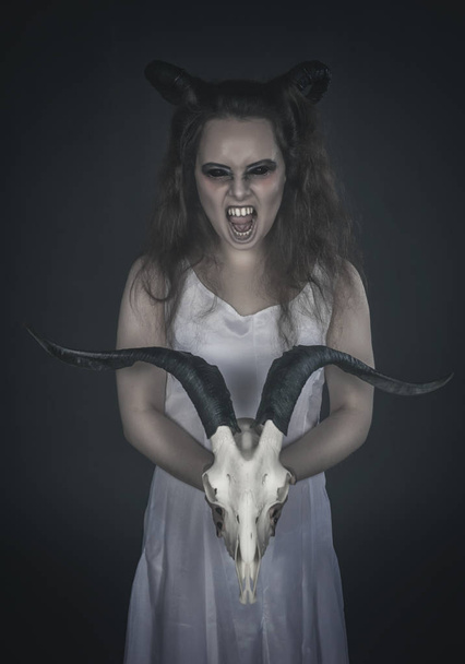 Schreckliches schreiendes Gespenst mit Totenkopf auf dunklem Grund  - Foto, Bild