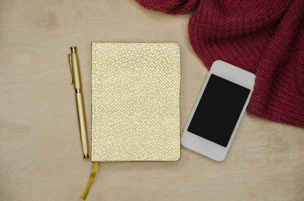 Goldener Notizblock mit Stift und Telefon - Foto, Bild