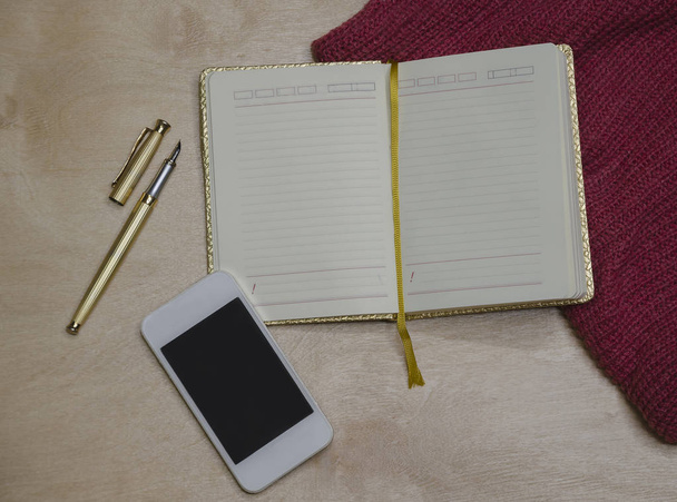 золотой блокнот с ручкой и телефоном
 - Фото, изображение
