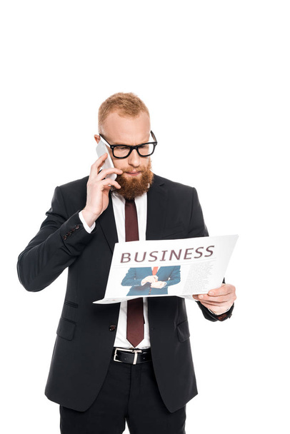 jeune homme d'affaires barbu dans les lunettes de lecture journal et parler sur smartphone isolé sur blanc
 - Photo, image