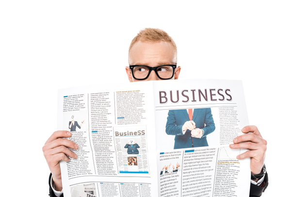mladý muž v brýlích schovává za obchodní noviny izolované na bílém - Fotografie, Obrázek