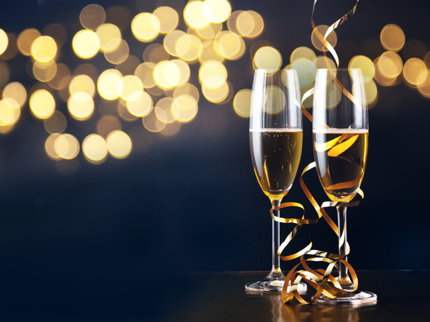 два бокала шампанского с лентами против праздничных огней и fi
 - Фото, изображение