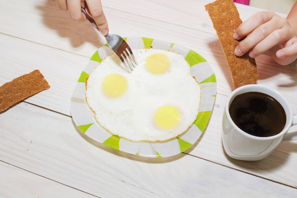 Café da manhã de três ovos e uma xícara de café quente
. - Foto, Imagem