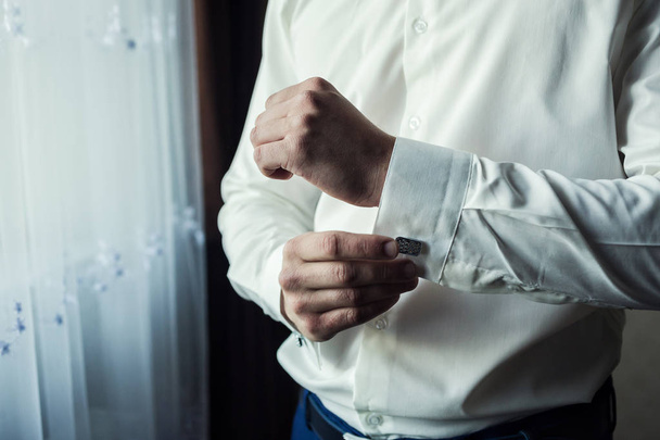 Geschäftsmann kleidet weißes Hemd, männliche Hände Nahaufnahme, Bräutigam macht sich morgens vor der Trauung fertig - Foto, Bild