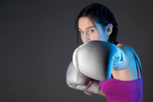 girl with the silver boxing gloves, black background with copy space - Foto, Bild