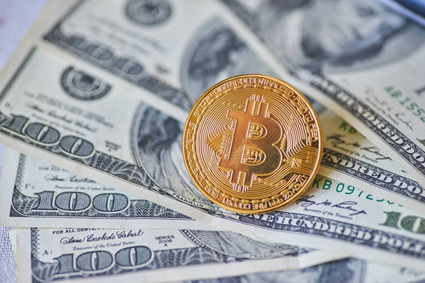 Golden metal bitcoin on dollar background - Photo, image