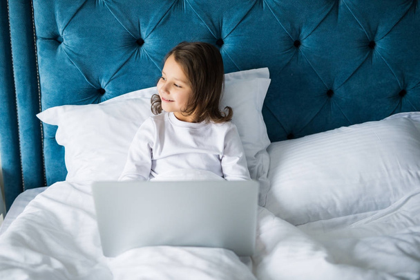 Trochę piękna dziewczyna z laptopa na łóżko w domu - Zdjęcie, obraz