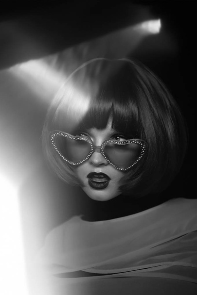 Spy girl in a charming way.Kare and glasses. Retro picture in black and white - Zdjęcie, obraz