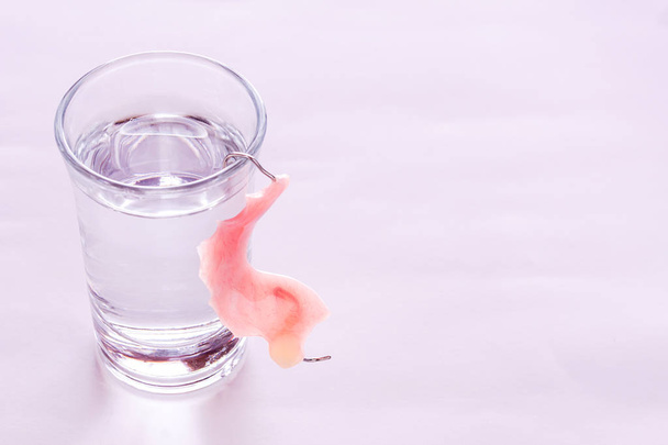 Lähikuva akryyli tekohampaat upotettu lasilliseen vettä
 - Valokuva, kuva