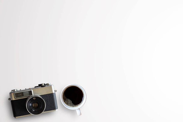 Cup of coffee and vintage camera on white background  - Photo, Image