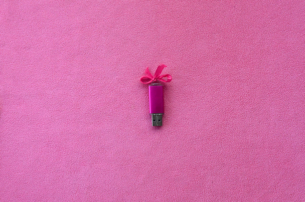 Ragyogó rózsaszín usb flash memória kártya-val egy rózsaszín orr fekszik egy takaró puha és Szőrős világos rózsaszín polár anyagból készült. Klasszikus női ajándék design memóriakártya - Fotó, kép