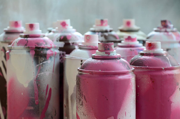 Un sacco di bombolette spray sporche e usate di vernice rosa brillante. Fotografia macro con bassa profondità di campo. Focus selettivo sull'ugello a spruzzo
 - Foto, immagini