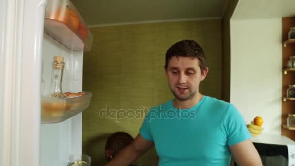 A man takes out fresh vegetables from the refrigerator. A vegetarian opens the refrigerator in the kitchen. - Filmagem, Vídeo