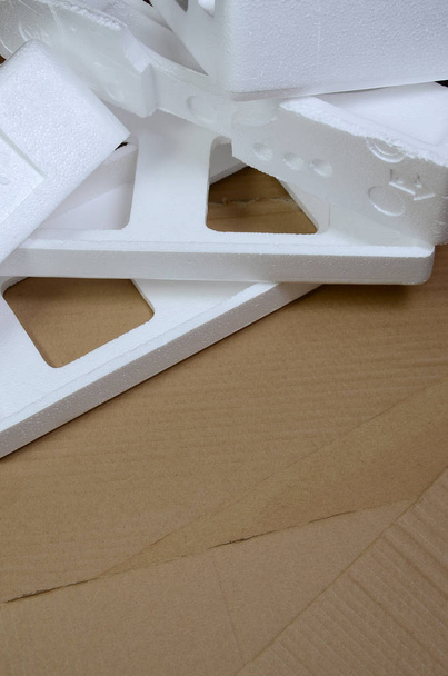 Фоновое изображение с бежевой картонной бумагой и пенопластовыми коробками, обесцениваемыми как мусор. Концепция распаковки новой бытовой техники из коробки
 - Фото, изображение