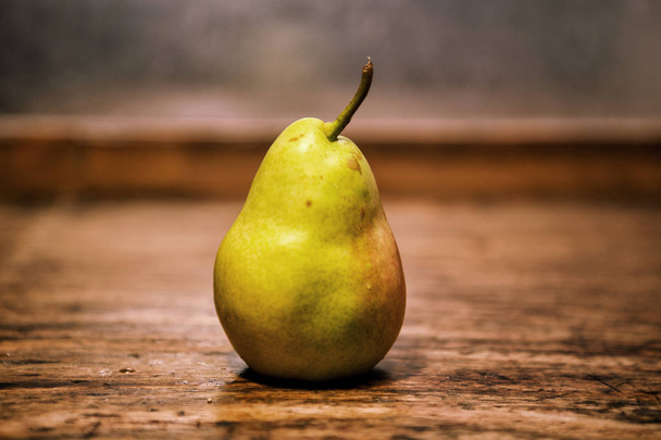 pear on a rustic wooden table - Zdjęcie, obraz
