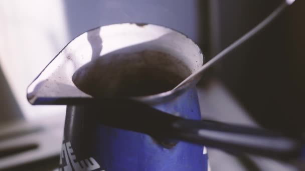 Caffè in pentola di metallo in fiamme da cucina a gas con cucchiaio di metallo e vapore
 - Filmati, video