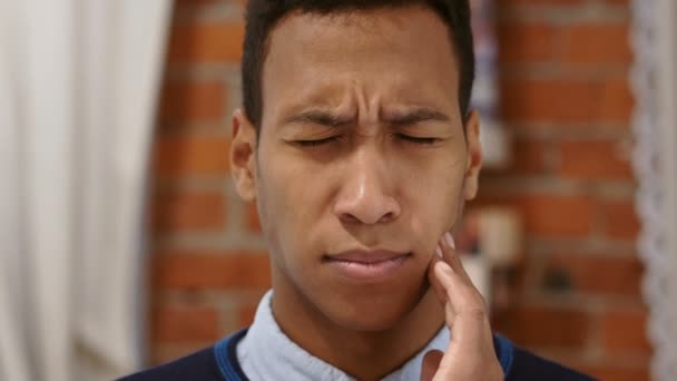 Frustrado hombre africano acostado en la cama sufriendo dolor de dientes, dolor de muelas
 - Metraje, vídeo
