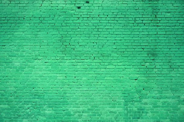De textuur van de bakstenen muur met vele rijen van bakstenen geschilderd in groene kleur - Foto, afbeelding