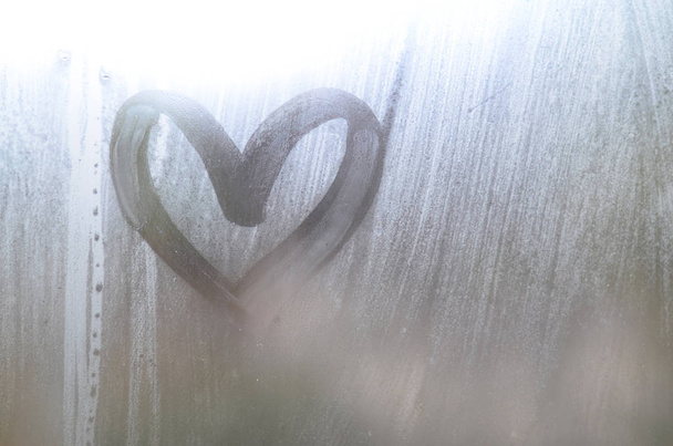 Sydämen muotoinen piirros, jonka sormi piirtää sumutettuun lasiin sateisella säällä
 - Valokuva, kuva